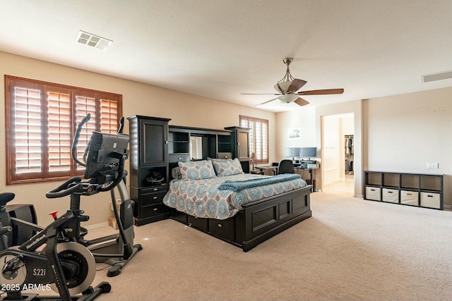 bedroom with visible vents, ceiling fan, and light carpet