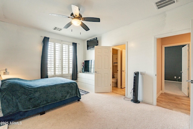 bedroom featuring carpet floors, visible vents, a ceiling fan, and ensuite bathroom