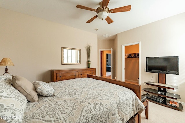 bedroom with carpet floors, ceiling fan, a spacious closet, and a closet