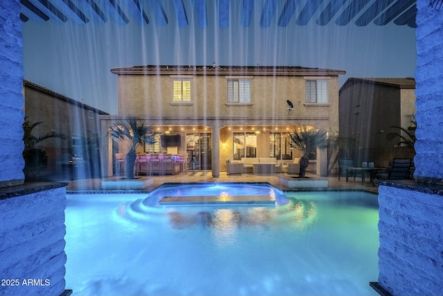 view of pool featuring a pool with connected hot tub, a patio area, and an outdoor living space