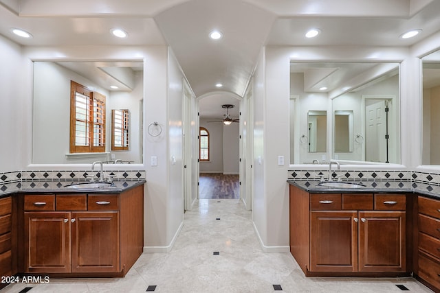 bathroom with ceiling fan, vanity, and tasteful backsplash