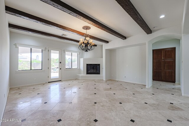 unfurnished living room with beamed ceiling and a chandelier