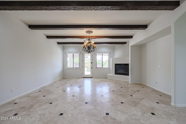 unfurnished living room featuring beamed ceiling and a notable chandelier