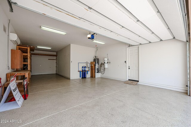 garage with water heater, a garage door opener, and a wall unit AC