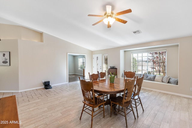 dining room with ceiling fan, lofted ceiling, and light hardwood / wood-style floors