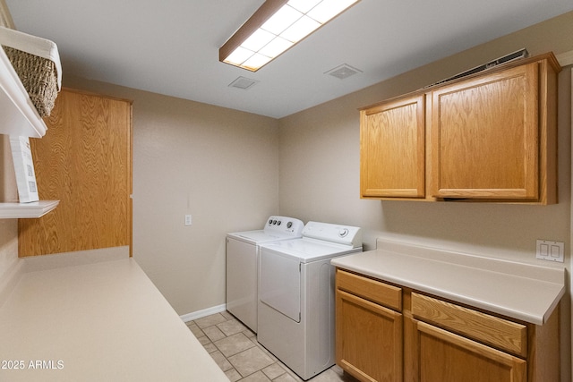 washroom featuring light tile patterned flooring, cabinets, and washer and clothes dryer