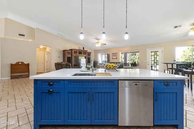 kitchen with blue cabinetry, ceiling fan, hanging light fixtures, an island with sink, and stainless steel dishwasher