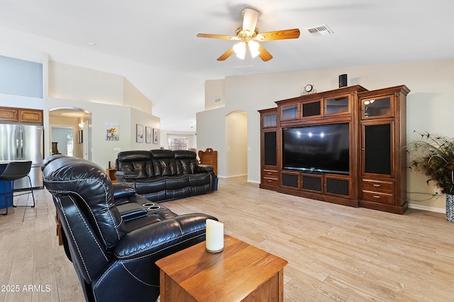 living room featuring light hardwood / wood-style flooring, high vaulted ceiling, and ceiling fan