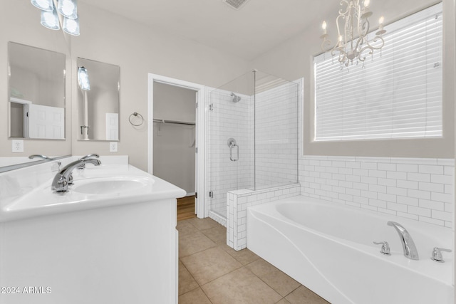 bathroom with tile patterned flooring, vanity, plus walk in shower, and a notable chandelier