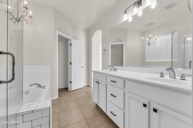 bathroom featuring tile patterned floors, tiled bath, and vanity