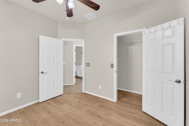 unfurnished bedroom featuring ceiling fan, a closet, and light wood-type flooring