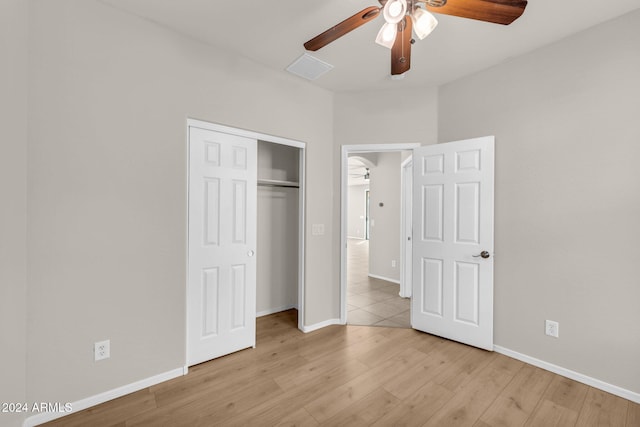 unfurnished bedroom featuring a closet, light hardwood / wood-style flooring, and ceiling fan