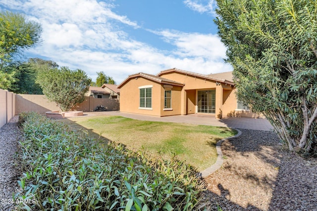 rear view of house with a yard and a patio