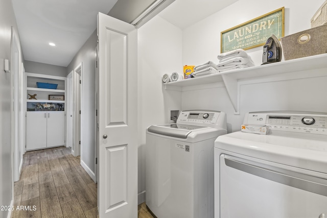 washroom with hardwood / wood-style flooring and washing machine and dryer