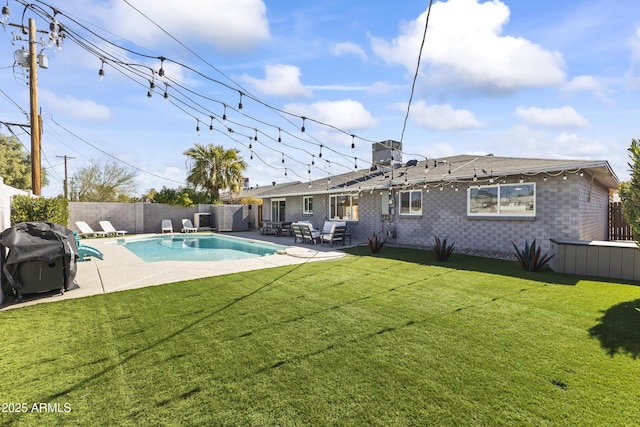 view of swimming pool featuring a patio, a grill, and a yard