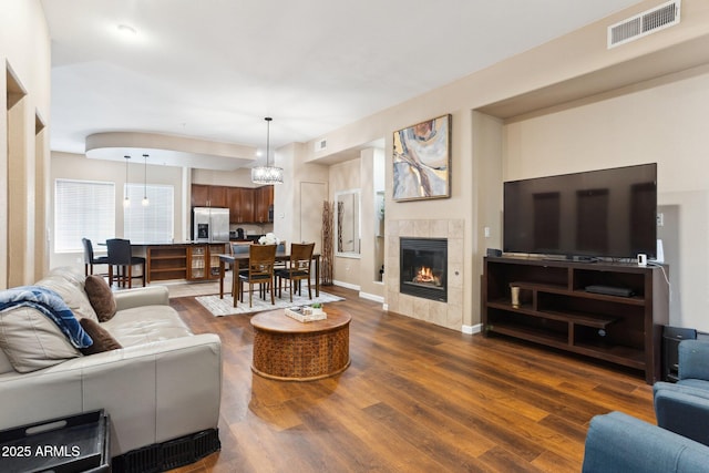 living room with dark hardwood / wood-style flooring and a tile fireplace