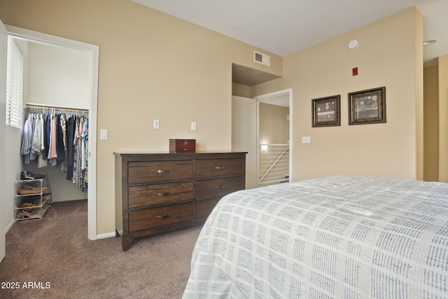 carpeted bedroom featuring a spacious closet and a closet