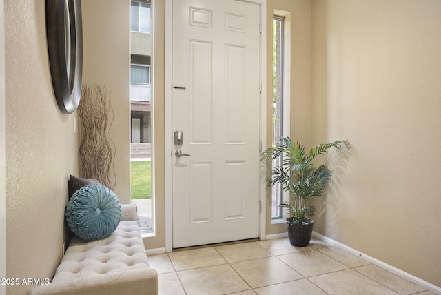 foyer with baseboards and light tile patterned floors