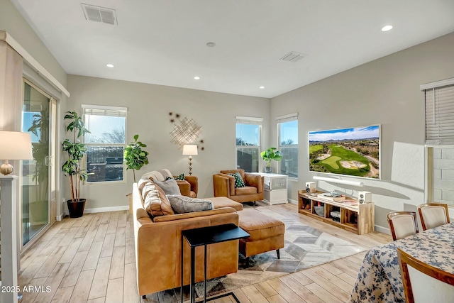 living room with recessed lighting, plenty of natural light, light wood-style floors, and visible vents