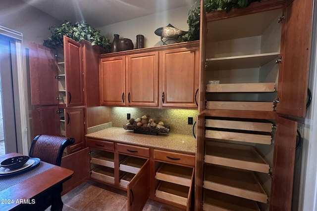 kitchen featuring backsplash and dark tile patterned flooring