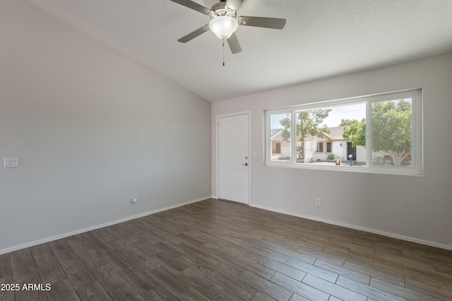 unfurnished room with a ceiling fan, dark wood-style flooring, baseboards, and vaulted ceiling