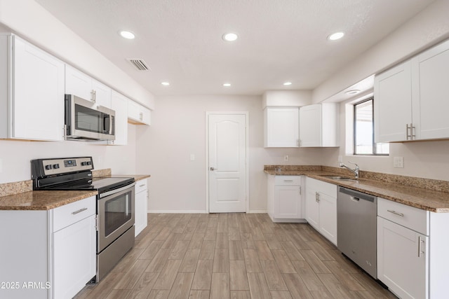 kitchen featuring light wood finished floors, a sink, visible vents, appliances with stainless steel finishes, and recessed lighting