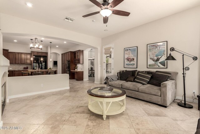 9747 S 182nd Dr, Goodyear, AZ 85338 - living area with visible vents, baseboards, arched walkways, recessed lighting, and ceiling fan with notable chandelier