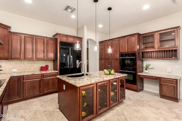 9747 S 182nd Dr, Goodyear, AZ 85338 - kitchen with tasteful backsplash, a sink, visible vents, arched walkways, and black appliances