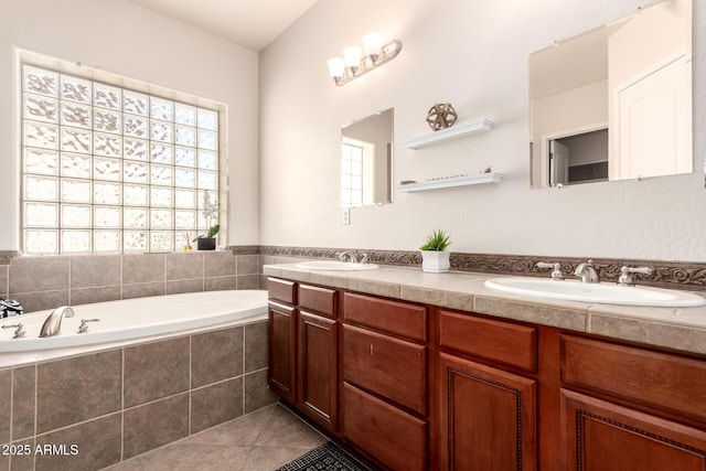 9747 S 182nd Dr, Goodyear, AZ 85338 - bathroom featuring a garden tub, a sink, tile patterned flooring, and a wealth of natural light