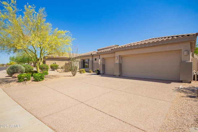 9747 S 182nd Dr, Goodyear, AZ 85338 - mediterranean / spanish-style house with a tile roof, an attached garage, driveway, and stucco siding