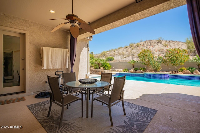 9747 S 182nd Dr, Goodyear, AZ 85338 - view of patio / terrace featuring outdoor dining space, a fenced in pool, a mountain view, a fenced backyard, and ceiling fan
