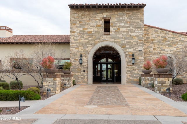 9747 S 182nd Dr, Goodyear, AZ 85338 - entrance to property featuring a tiled roof, french doors, stone siding, and stucco siding