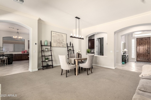 9747 S 182nd Dr, Goodyear, AZ 85338 - carpeted dining area with ornamental molding, visible vents, arched walkways, and an inviting chandelier