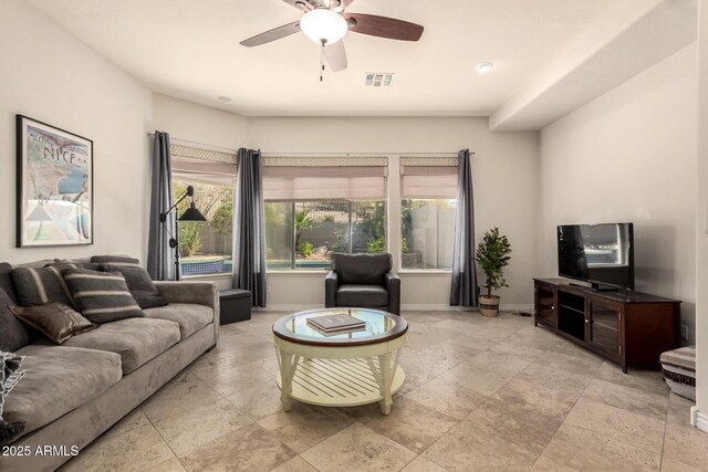 9747 S 182nd Dr, Goodyear, AZ 85338 - living room featuring visible vents, baseboards, a ceiling fan, and stone tile floors