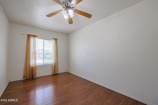 empty room with ceiling fan and dark wood-type flooring