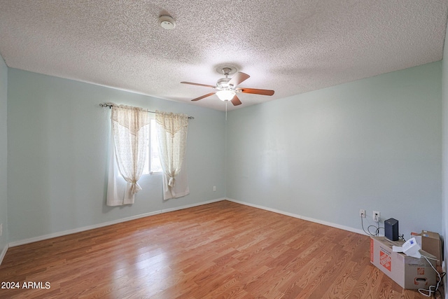 spare room with a textured ceiling, light hardwood / wood-style floors, and ceiling fan