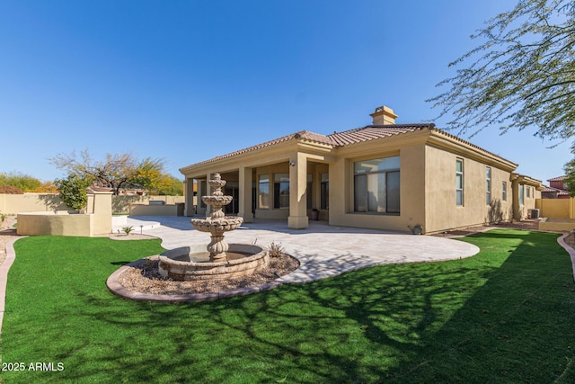 back of property with a yard and a patio area