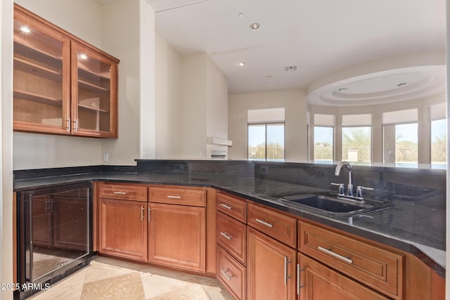 kitchen featuring wine cooler, sink, plenty of natural light, and dark stone counters