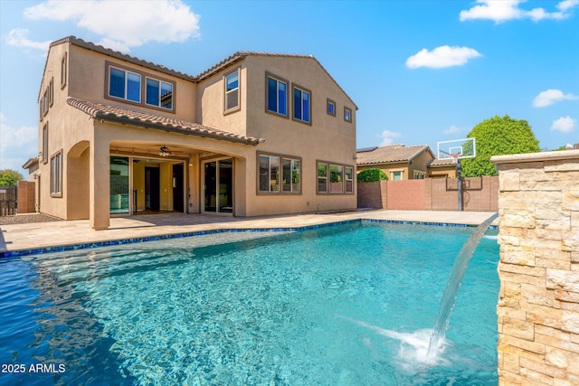 view of pool with pool water feature, ceiling fan, and a patio area