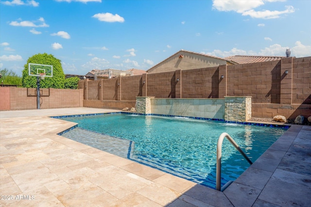 view of swimming pool featuring pool water feature and basketball hoop