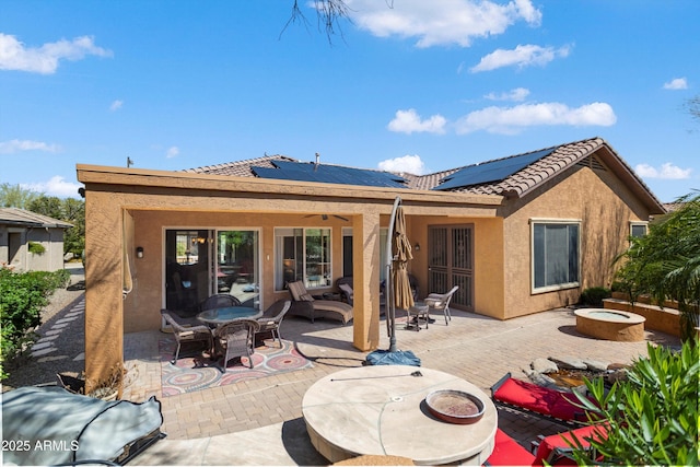 26293 W Runion Ln, Buckeye, AZ 85396 - back of property featuring stucco siding, roof mounted solar panels, outdoor dining area, a patio area, and a tiled roof