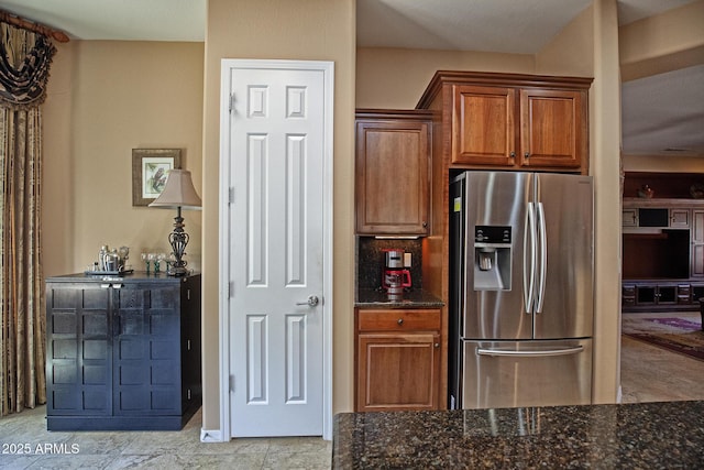 26293 W Runion Ln, Buckeye, AZ 85396 - kitchen featuring dark stone counters, stainless steel fridge with ice dispenser, and brown cabinets