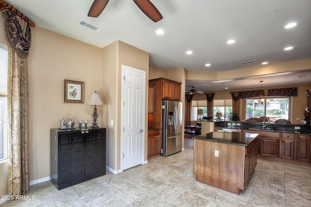 26293 W Runion Ln, Buckeye, AZ 85396 - kitchen featuring a kitchen island, visible vents, stainless steel fridge, and ceiling fan with notable chandelier