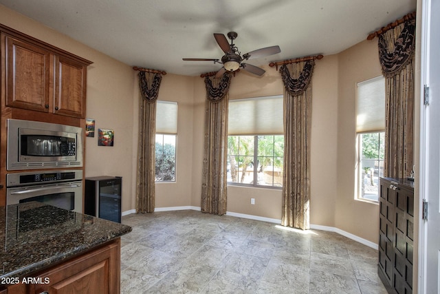 26293 W Runion Ln, Buckeye, AZ 85396 - kitchen with dark stone counters, ceiling fan, appliances with stainless steel finishes, and plenty of natural light
