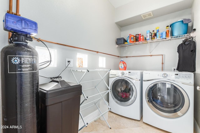 laundry room featuring light tile patterned flooring and washing machine and dryer