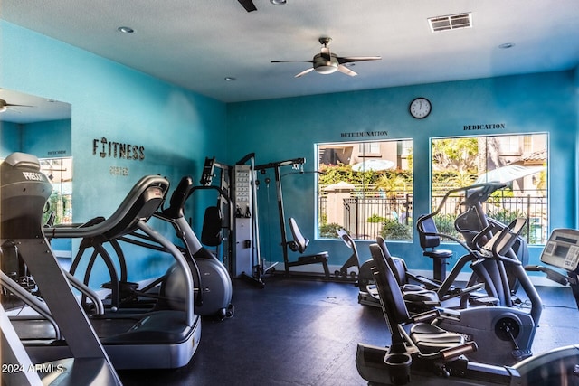 exercise room featuring a textured ceiling, a wealth of natural light, and ceiling fan