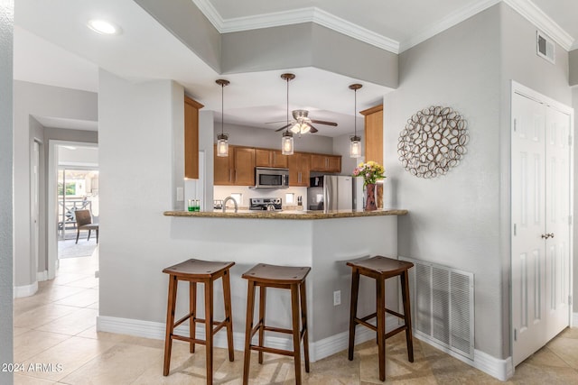 kitchen with hanging light fixtures, ornamental molding, stainless steel appliances, and kitchen peninsula