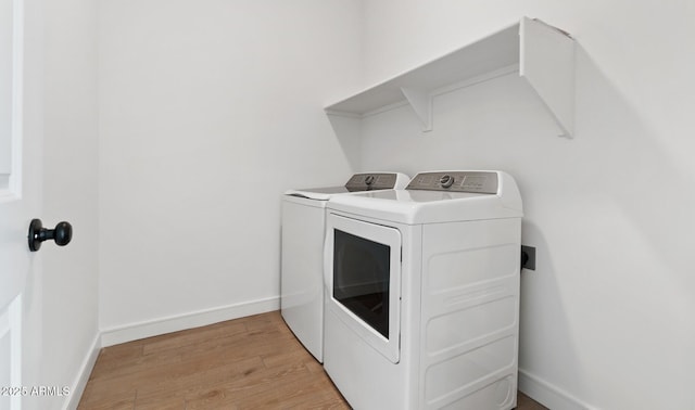 washroom with light wood-type flooring and washing machine and clothes dryer