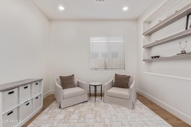 living area featuring wood finished floors, baseboards, and recessed lighting