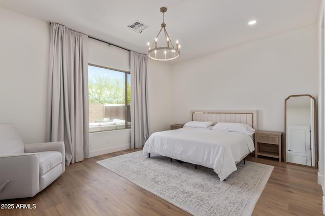 bedroom featuring a chandelier, wood finished floors, recessed lighting, and baseboards